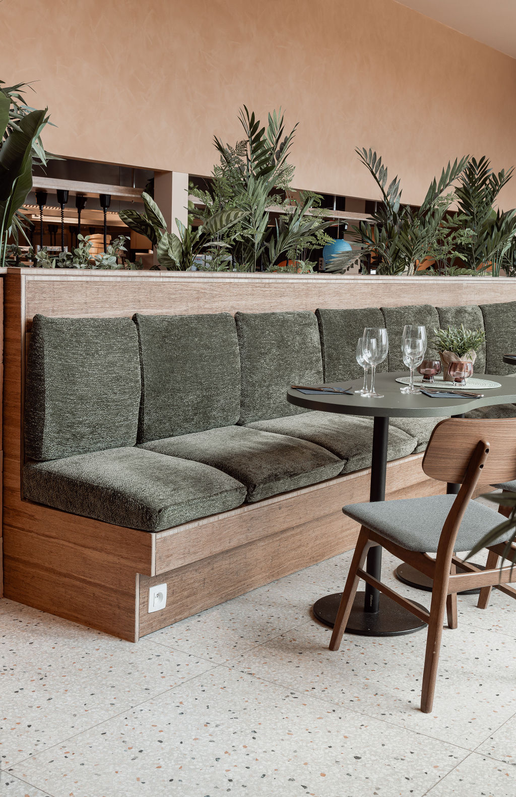 restaurant met terrazzo vloer, houten zitbank en groene stoffering renovatie horeca inrichting Sint-Niklaas