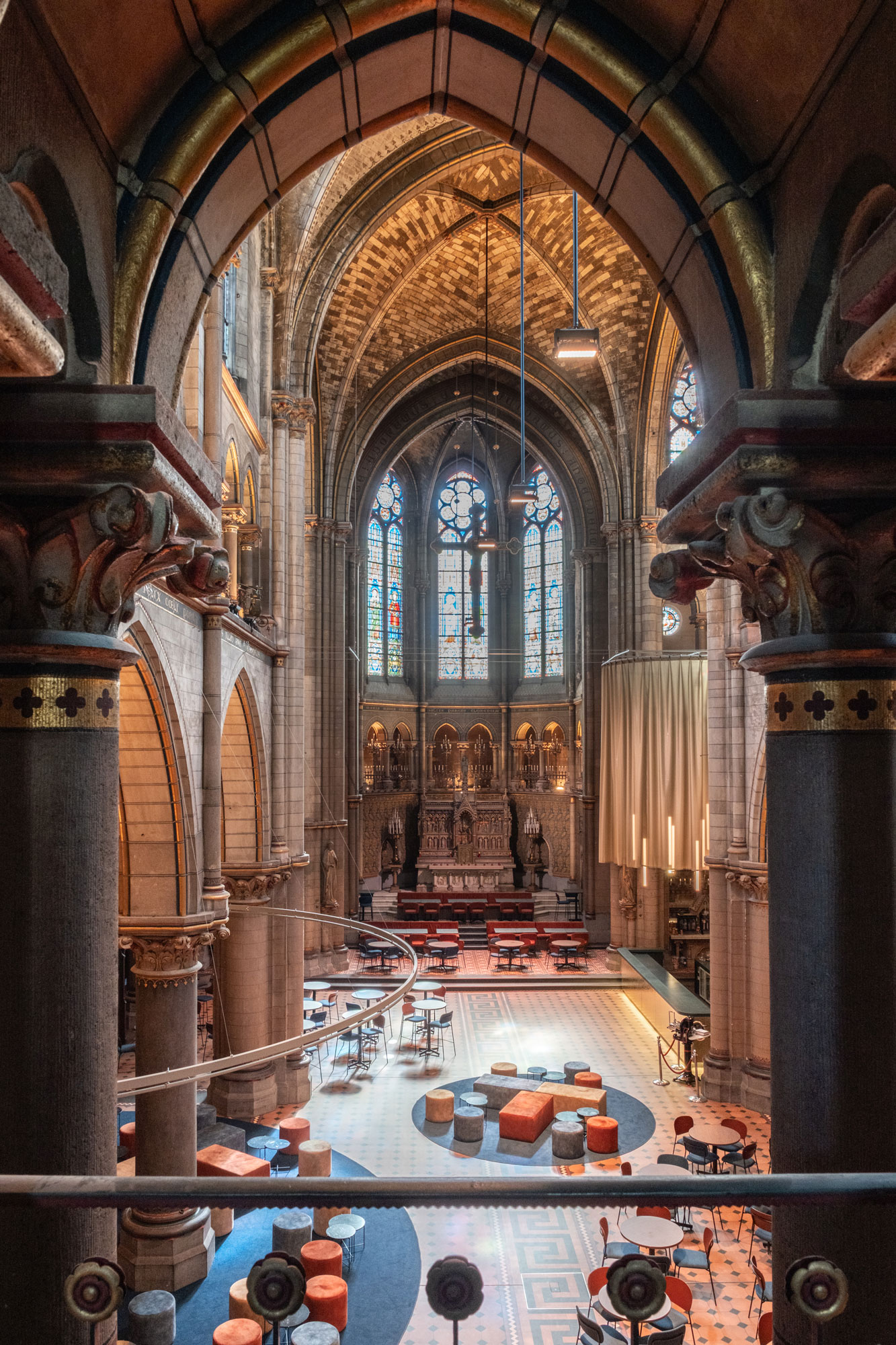kerk als theaterfoyer met bar, tafels en stoelen gordijnen interieurinrichting restauratie en herbestemming Antwerpen