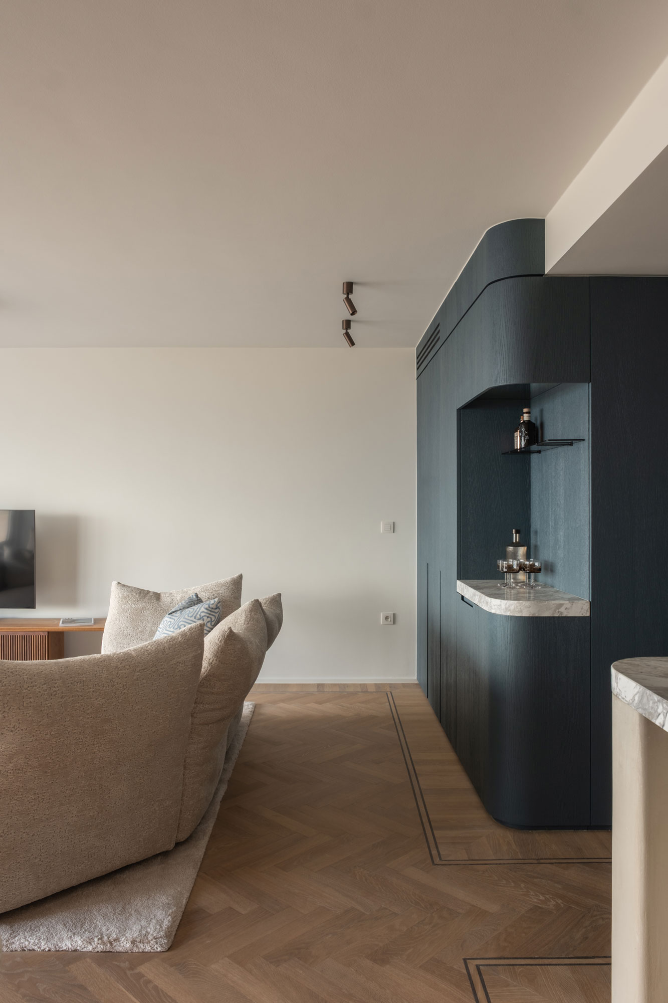 leefruimte parketvloer gelakte eikenhouten maatkast met natuursteen en zetel interieurinrichting appartement kustappartement Knokke