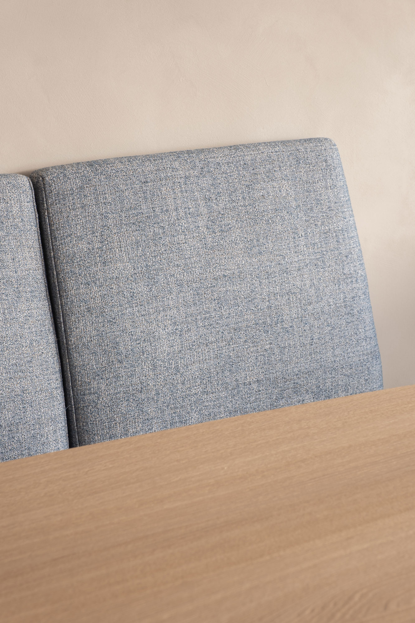eetkamer zitbank blauwe kussens en houten tafel interieurinrichting appartement kustappartement Knokke