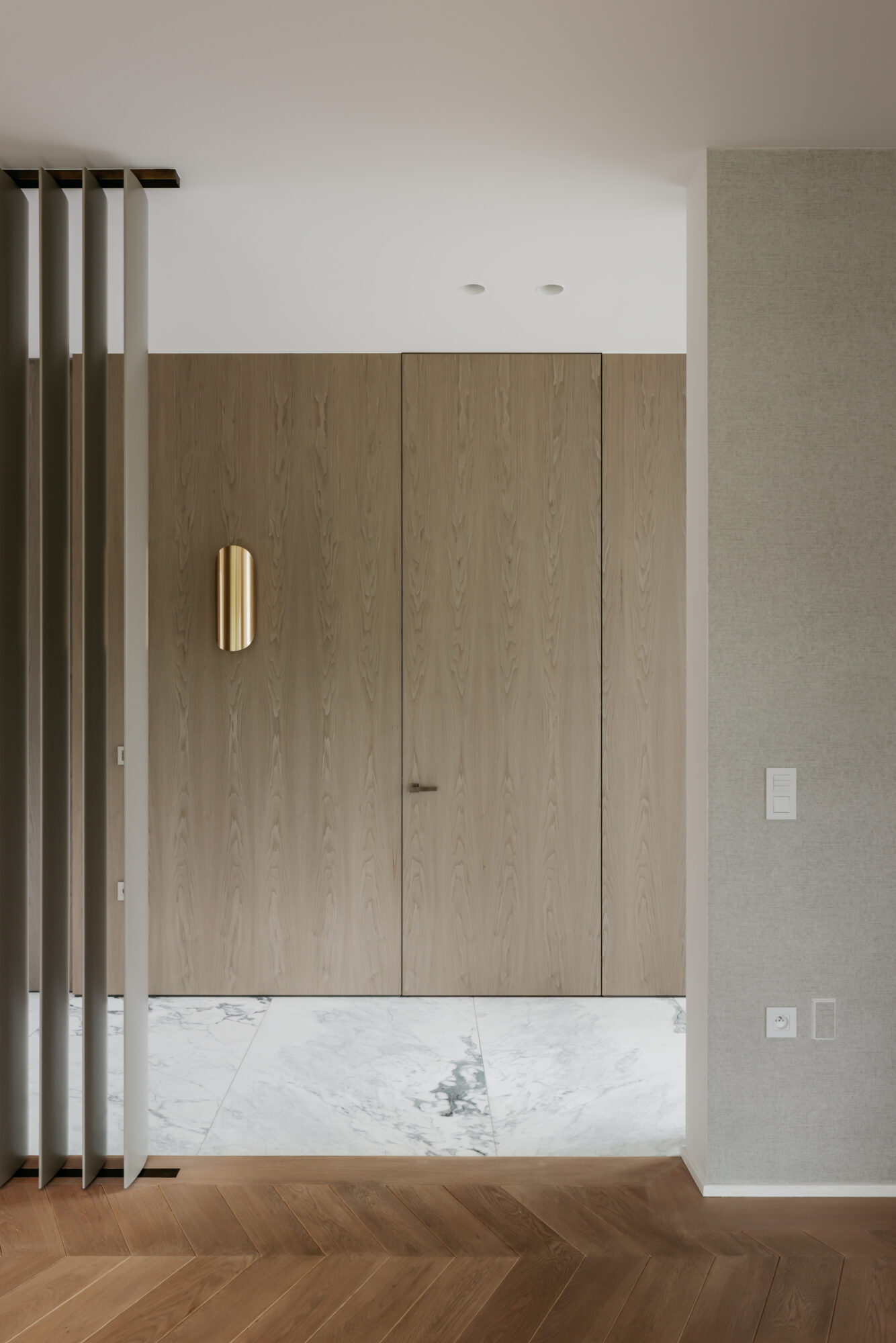 houten wandbekleding maatwerk ingewerkte deur en gouden wandarmatuur interieurinrichting nieuwbouwwoning Edegem