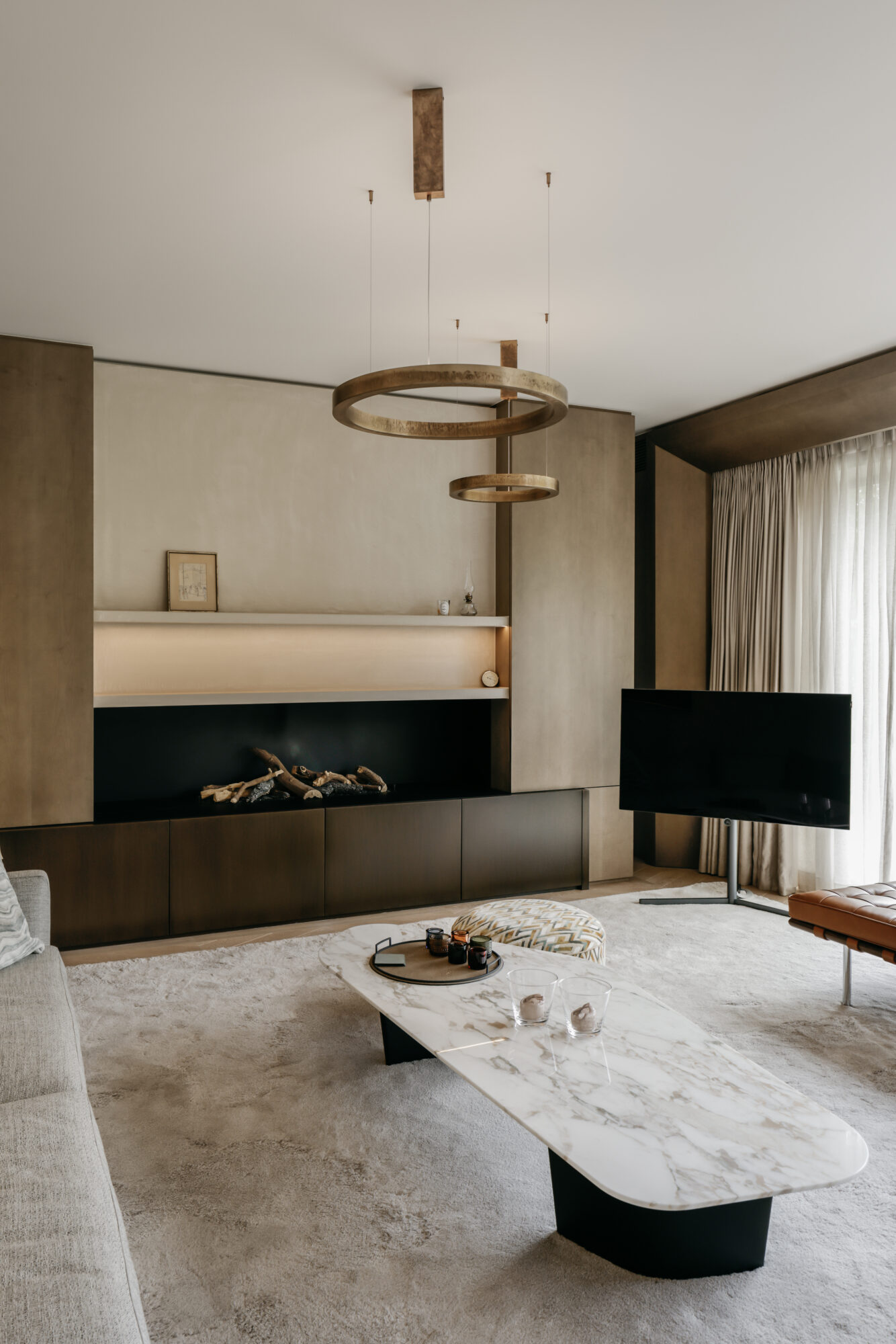 leefruimte met haard, tapijt en maatwerk interieurinrichting nieuwbouwwoning Edegem