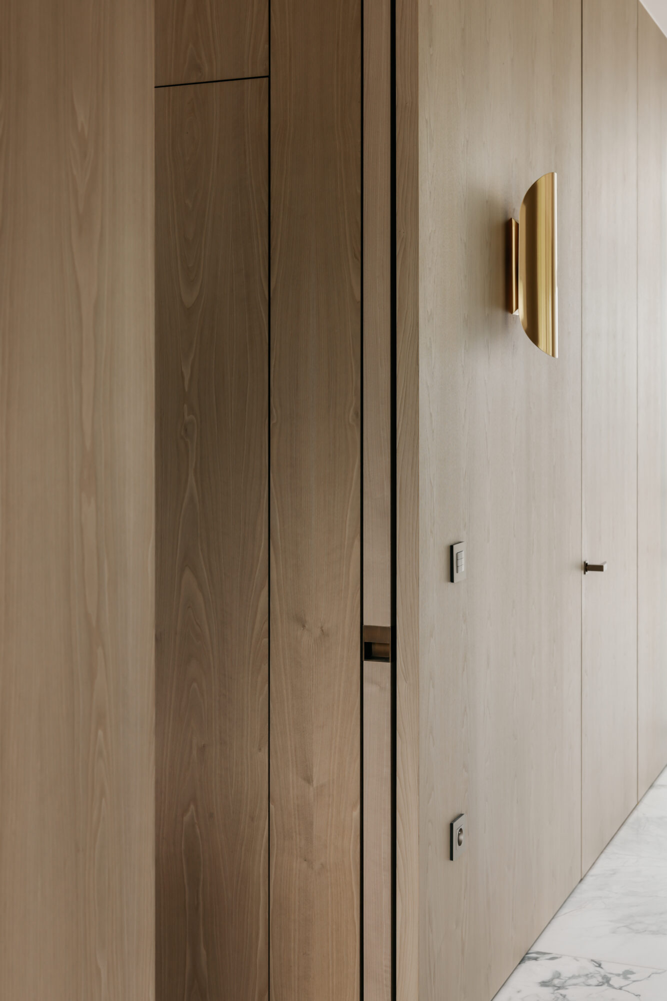 houten maatwerk met schuifdeur en gouden wandarmatuur interieurinrichting nieuwbouwwoning Edegem
